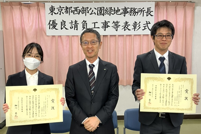 優良請負工事等表彰式の記念写真（伊野主任技術者、越後社長、大坪チームリーダー）